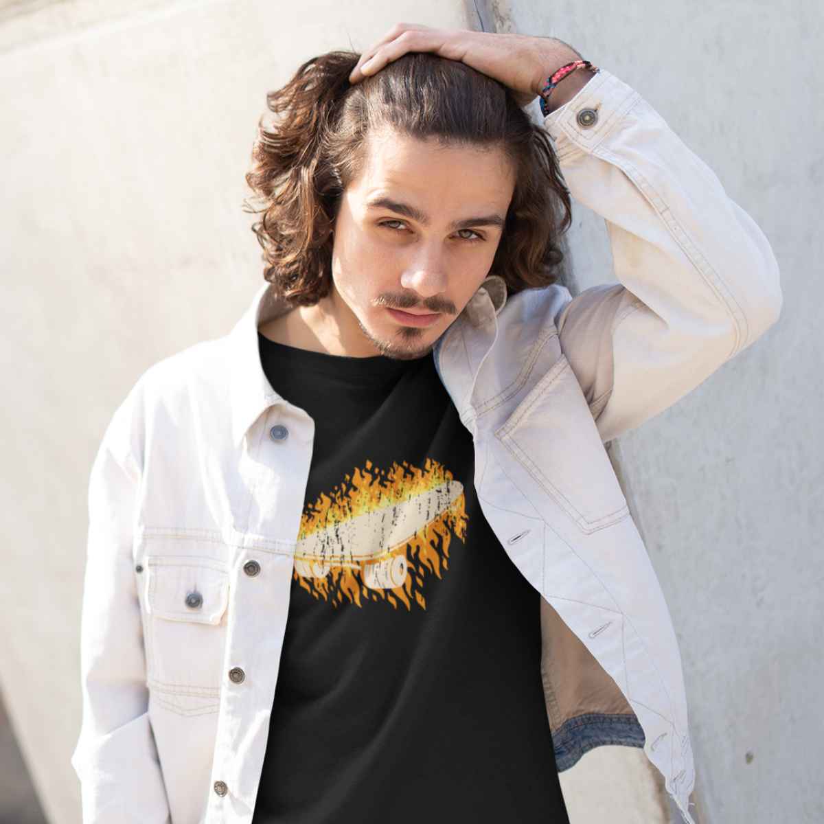 Junges männliches Model präsentiert schwarzes T-Shirt aus der Skateboard hiss off Kollektion von Roger Rockawoo Clothing und streicht sich dabei mit der Hand durch die Haare 