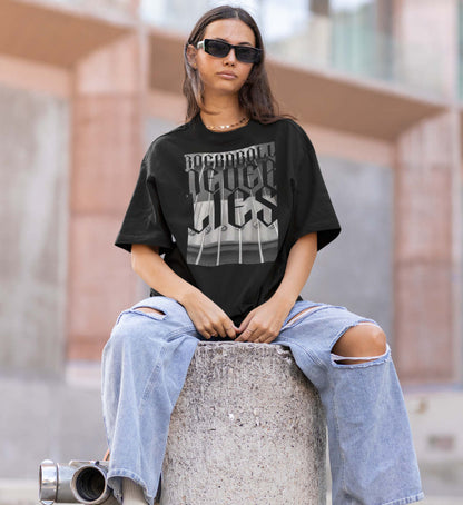Model trägt schwarzes T-Shirt Unisex Relaxed Fit für Frauen und Männer bedruckt mit dem Design der Roger Rockawoo Kollektion Rocknroll never lies